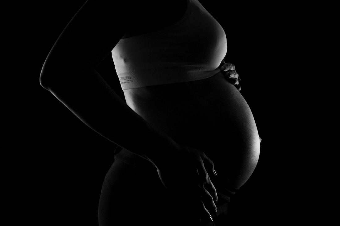 Grūtnieces siluets melnbaltā fotogrāfijā